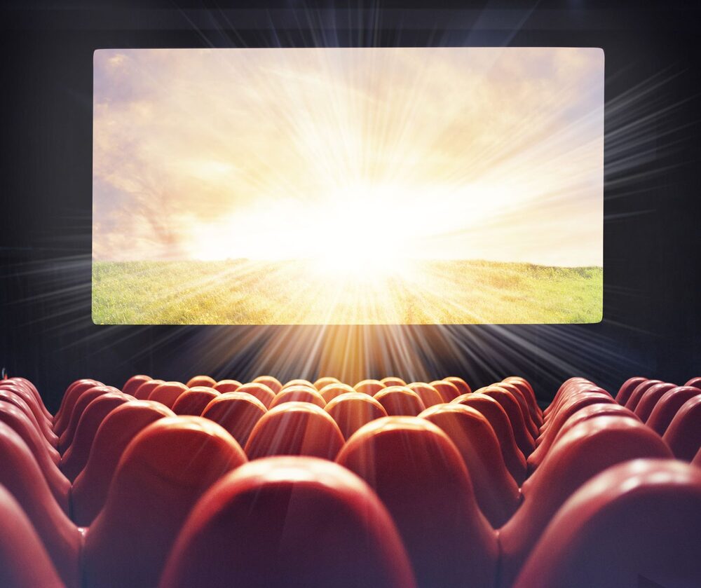 巨大スクリーンに没入する映画館の観客