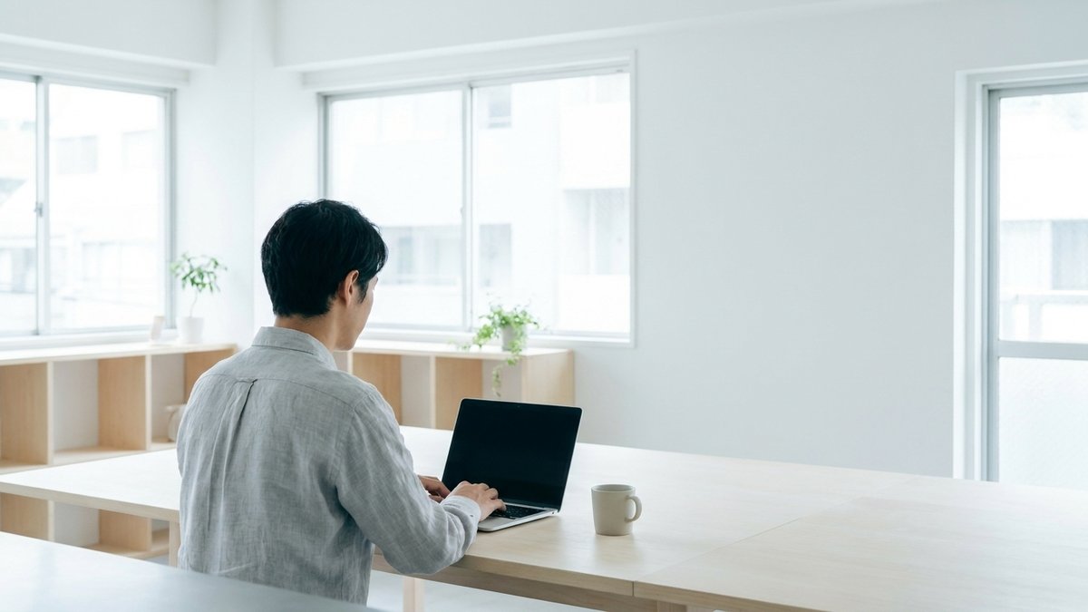 明るいオフィスのデスクでノートパソコンに向かい、広告の計測設定を進める様子